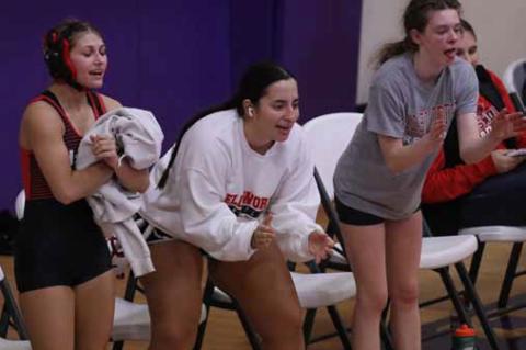 Members of the girls’ wrestling team cheer a teammate on. From left, Danica Hicks, Riley Rodriguez and Khloe Kinsley.