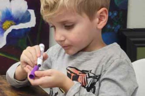Brighton Rennick works on some crafts during the Hometown Holiday event.