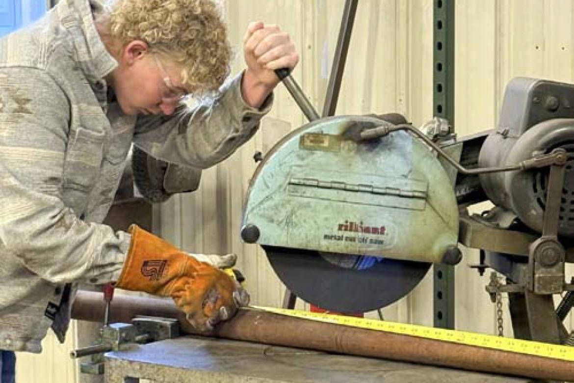 Sophomore Bo Kyler cuts pipe with a chop saw in the agriculture fabrication class. Ag fab is the advanced welding class.